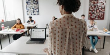 Female teacher engaging students in a classroom setting with diverse learners.