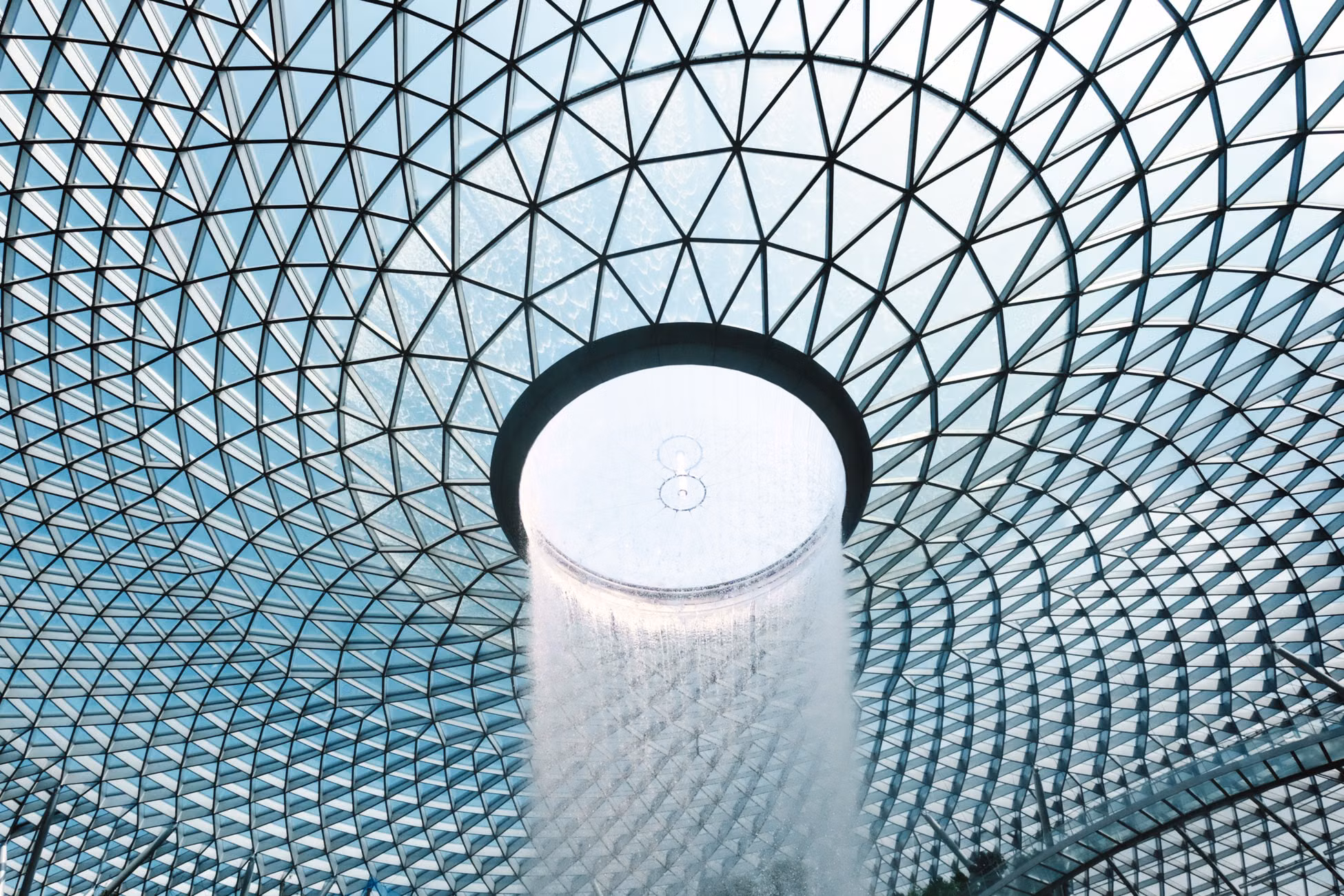 Stunning view of Jewel Changi Airport's vortex waterfall under a geometric glass dome.