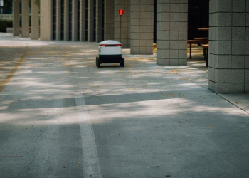 Futuristic autonomous robot on a delivery mission in a modern urban environment.