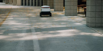 Futuristic autonomous robot on a delivery mission in a modern urban environment.