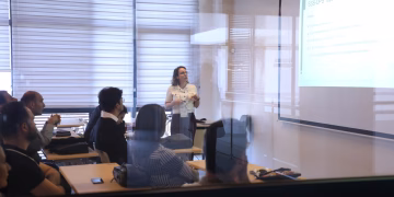 Audience attending a business presentation in a modern office environment.