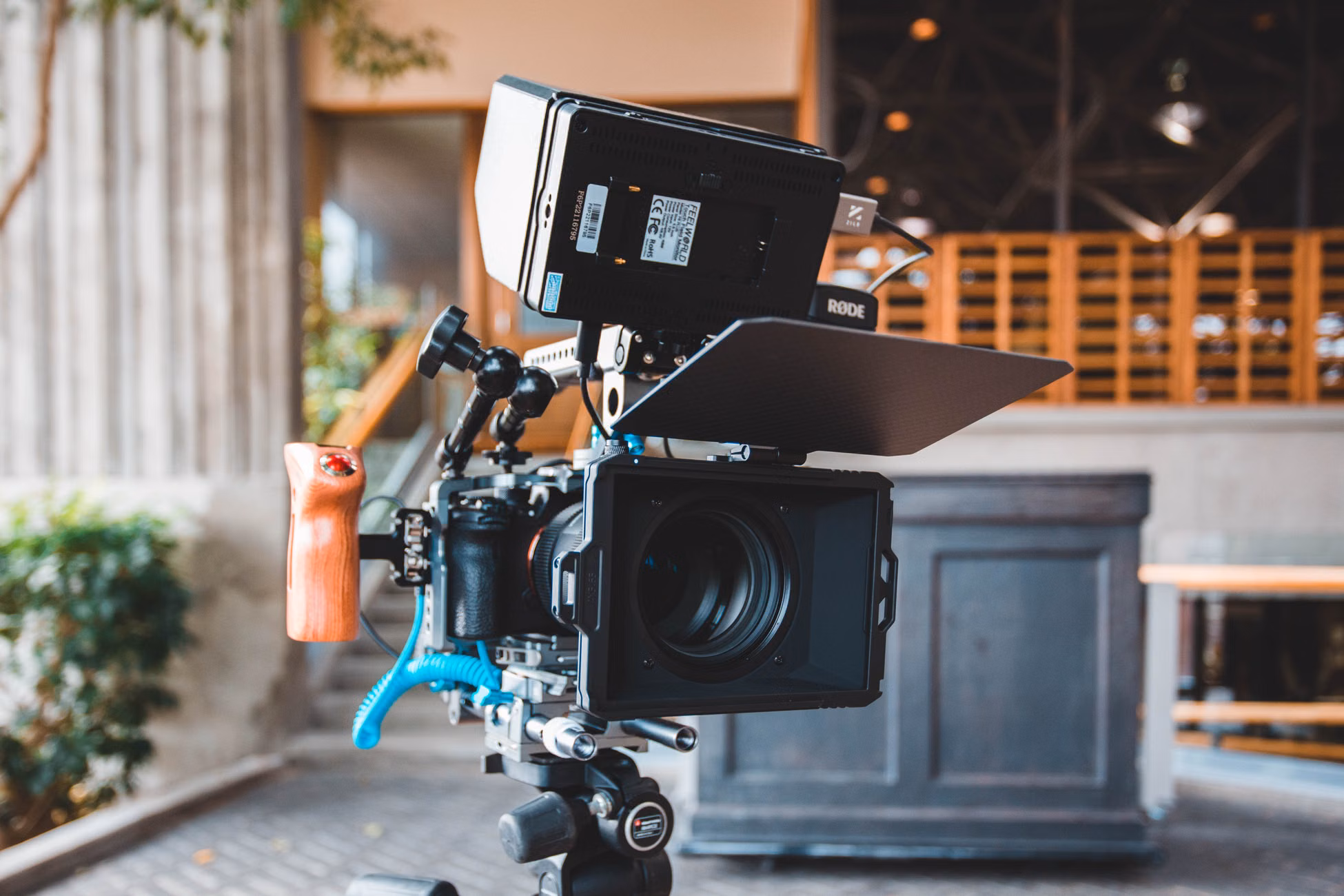 Close-up of a modern camera setup with a Rode monitor in a studio setting.