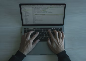 Close-up view of a programmer coding on a laptop, showcasing modern software development.