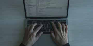 Close-up view of a programmer coding on a laptop, showcasing modern software development.