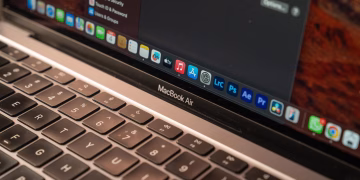A detailed view of a MacBook Air with a focus on the keyboard and screen displaying app icons.