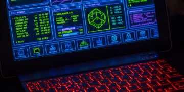 Futuristic digital interface displayed on laptop screen with neon red keyboard.
