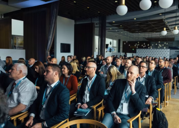 Business professionals attentively listening at an indoor conference meeting.
