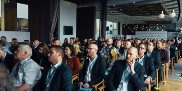 Business professionals attentively listening at an indoor conference meeting.