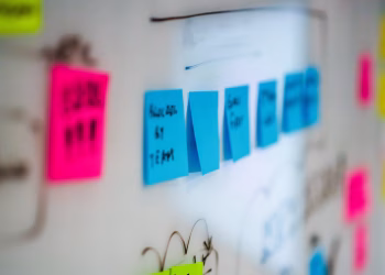 Sticky notes on a whiteboard during a creative brainstorming session in an office.