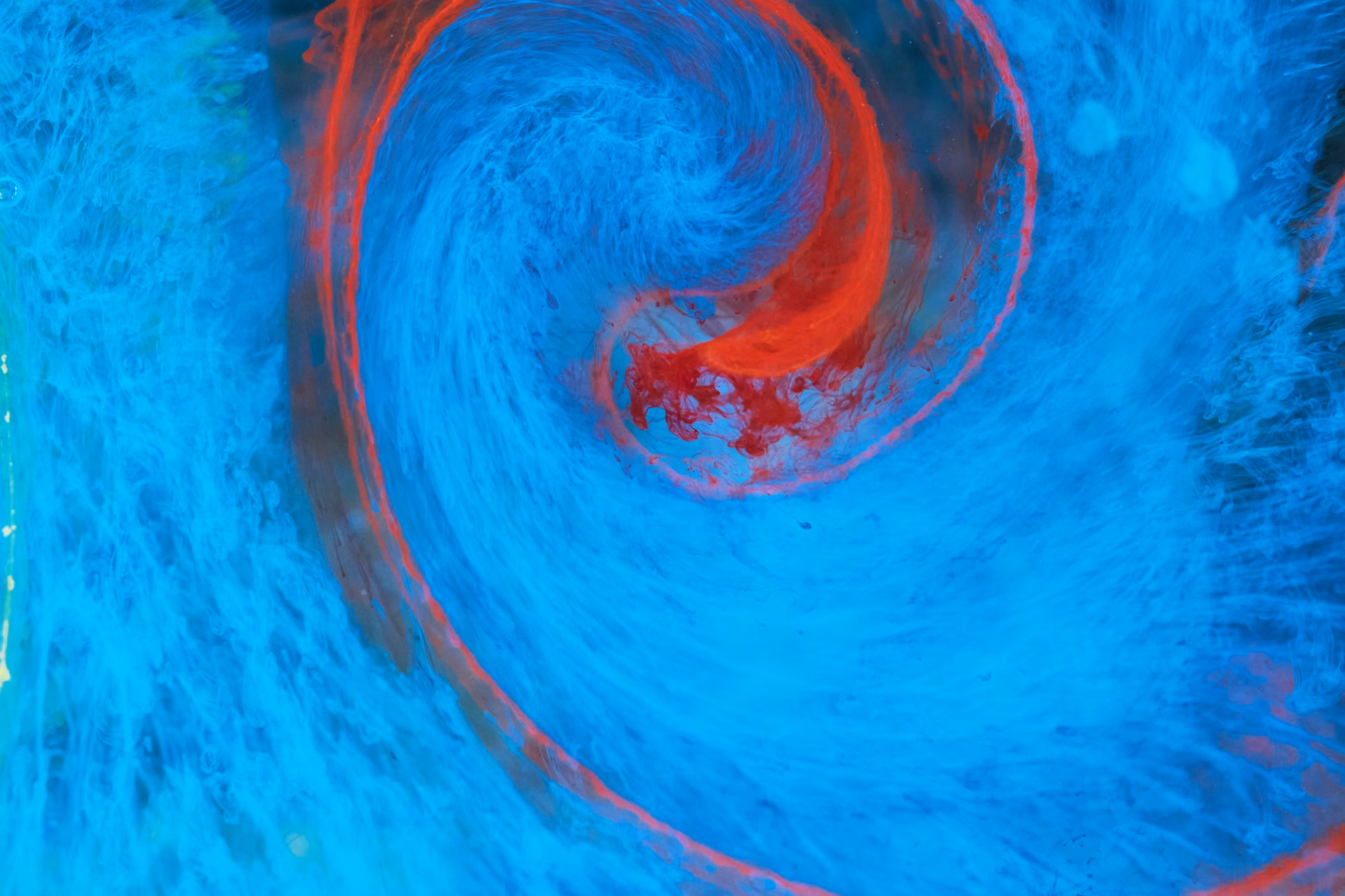 Dynamic abstract swirl of blue and red colors, resembling fluid motion.