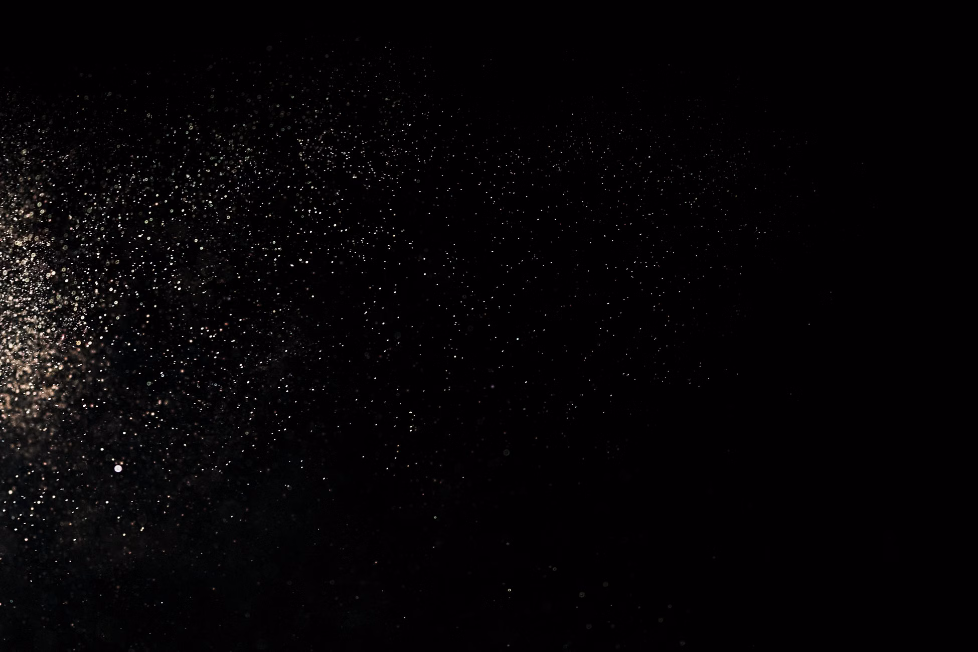 Captivating image of particles scattered across a dark backdrop, evoking a cosmic or dust effect.