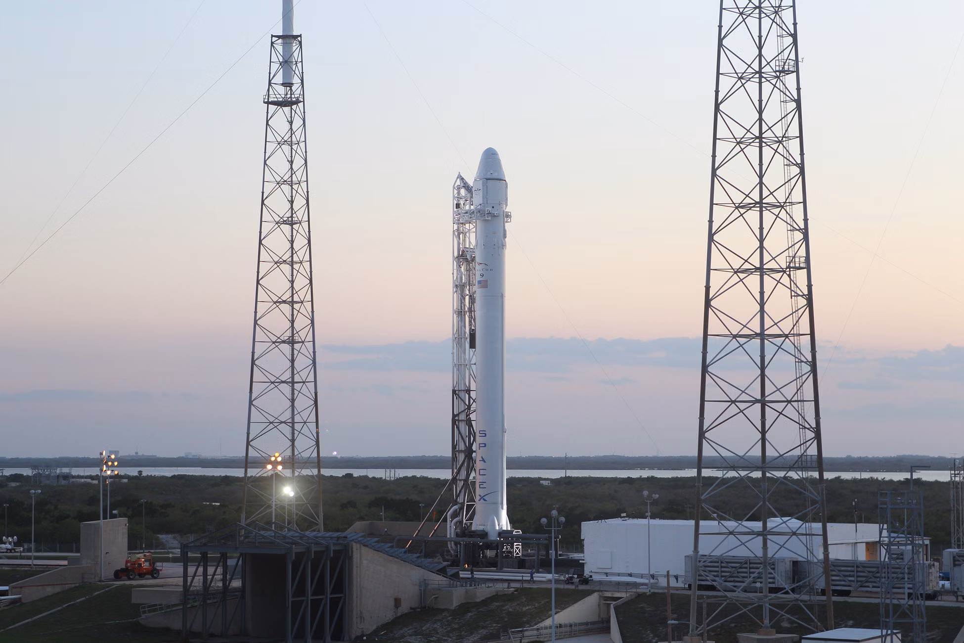 Space rocket installed on metal construction in spaceport and ready for launching against cloudless sky