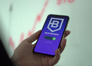 Hand holding smartphone displaying blockchain cryptocurrency wallet.