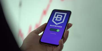 Hand holding smartphone displaying blockchain cryptocurrency wallet.