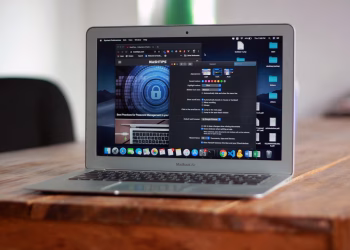 Open MacBook Air with apps and web browser on screen, placed on a wooden table indoors.