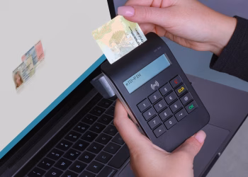 Person using contactless device for ID payment verification on a laptop.