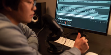 Sound engineer working on audio editing with a computer in a recording studio.