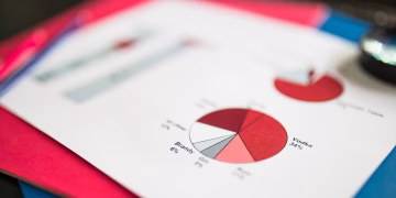 Close-up of financial pie chart on colorful paper, highlighting data analysis concepts.
