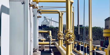 A detailed view of industrial pipelines in a Saudi Arabian factory setting.