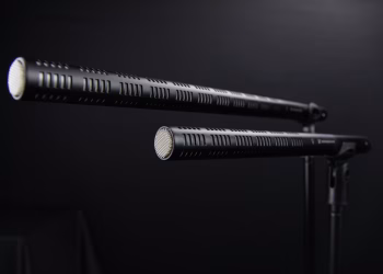 Close-up view of two professional shotgun microphones in a recording studio.
