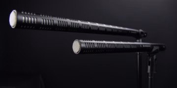 Close-up view of two professional shotgun microphones in a recording studio.