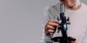 A scientist carefully examining samples using a microscope in a modern laboratory setting.