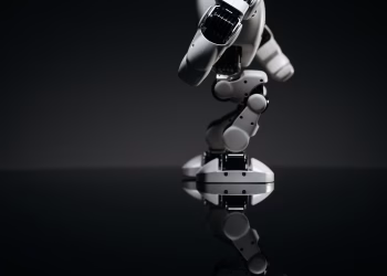 A close-up image of a mechanical robotic arm reflecting on a dark surface, capturing industrial innovation.
