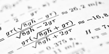Mathematical formulas are shown on the paper.