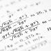 Mathematical formulas are shown on the paper.