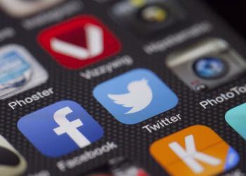 A detailed close-up of social media icons on a smartphone screen, including Facebook and Twitter.
