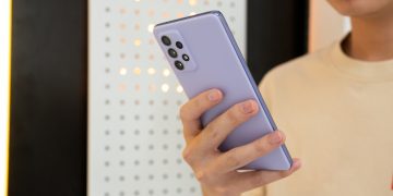 person holding white and blue iphone case