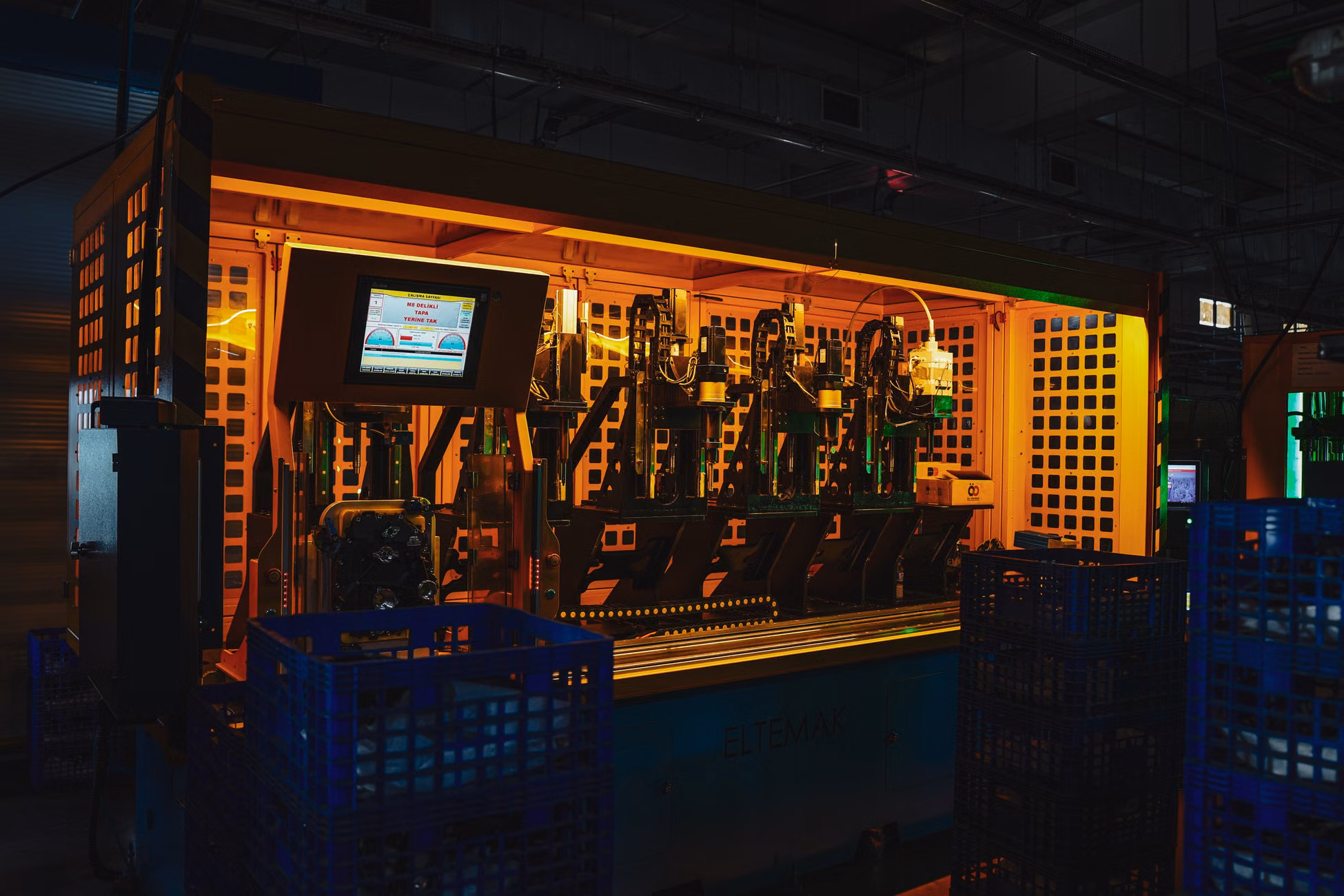 A complex piece of machinery in a dark industrial setting with vibrant lighting.