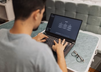 A man working on a laptop displaying ChatGPT's interface in an indoor setting.