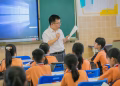 Teacher instructing attentive students in a classroom setting, fostering education and learning.
