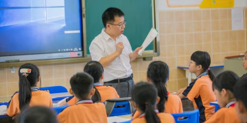 Teacher instructing attentive students in a classroom setting, fostering education and learning.
