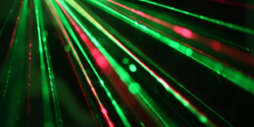 Dynamic display of red and green laser beams creating an abstract and vibrant visual effect.