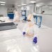 Workers in protective suits inside a cleanroom.