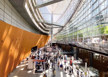 A bustling scene inside the modern architecture of Tokyo International Forum in Japan.