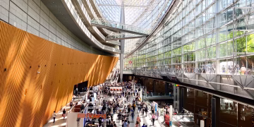 A bustling scene inside the modern architecture of Tokyo International Forum in Japan.