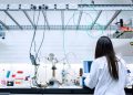 A female scientist conducting research in a contemporary laboratory full of equipment.