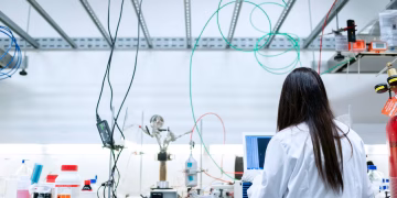 A female scientist conducting research in a contemporary laboratory full of equipment.