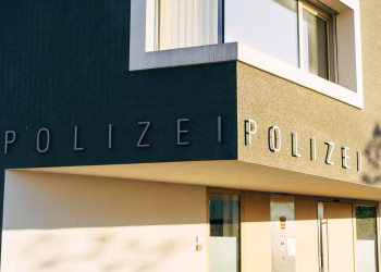 A close-up of a modern police station facade in Germany with clear signage.
