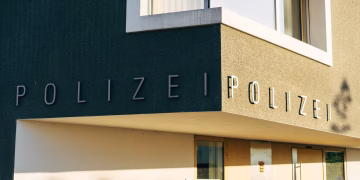 A close-up of a modern police station facade in Germany with clear signage.