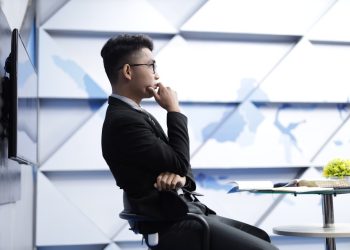man in black long sleeve shirt sitting on black chair