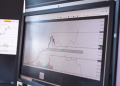Close-up of stock market analysis charts on a monitor, showcasing market trends.