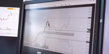 Close-up of stock market analysis charts on a monitor, showcasing market trends.