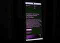 a cell phone with a lit up screen in the dark