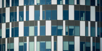 Close-up of a modern office building facade with geometric patterns and glass windows.