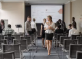 Professionals at a business conference engage before a presentation in a modern office.