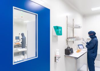 a person in a lab coat looking at a mirror